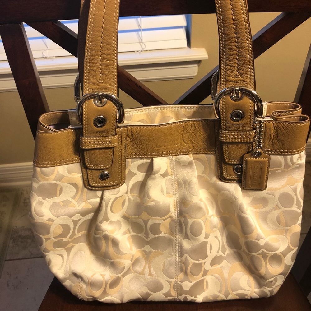 Tan and cream colored Coach purse.